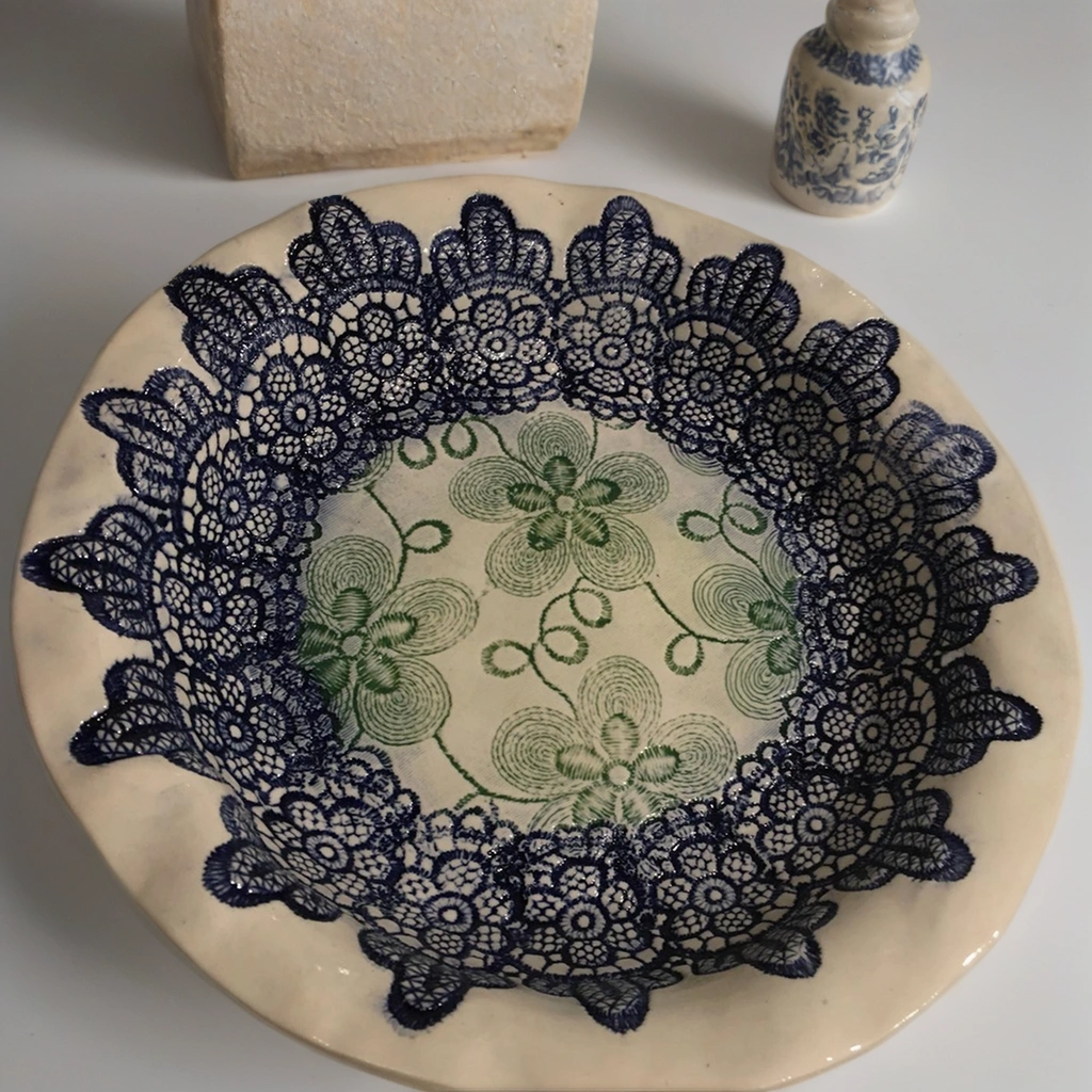 Ceramic plate with lace-imprinted border and floral detail