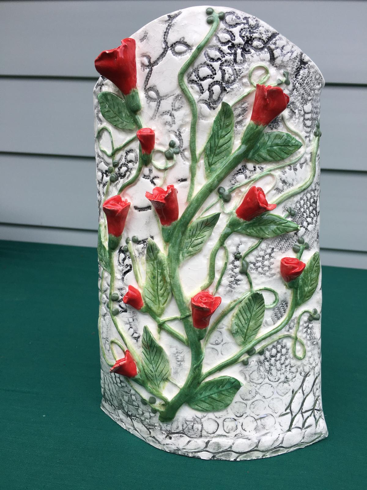 White ceramic vase with applied red roses and lace texture